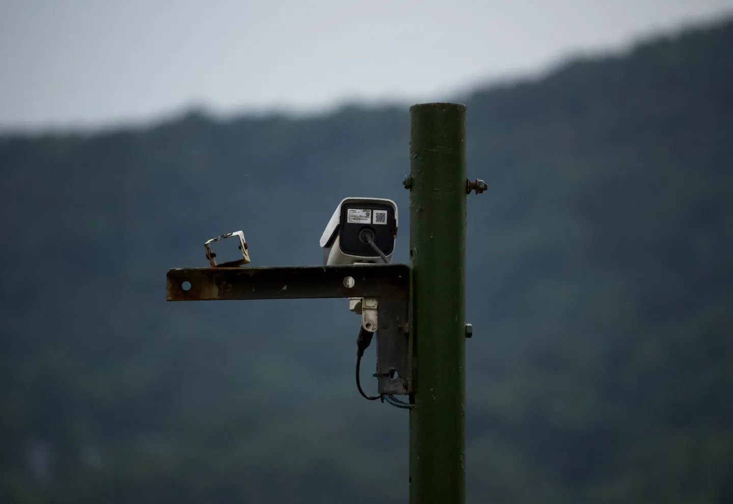 Caméra de vidéosurveillance fixée sur un mât, en contre-plongée sur un ciel dégagé